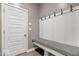 Mudroom with a white bench with black and white checkered fabric and hooks on the wall for coats and backpacks at 8547 Winton Pl, Pendleton, IN 46064