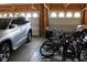 Spacious garage featuring two garage doors, a silver SUV, and an assortment of bicycles and lawn equipment at 9068 Thames Dr, Avon, IN 46123