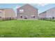A spacious backyard featuring lush green grass, black metal fencing, and backing up to neighbors at 9498 Tobin Cir, Avon, IN 46123