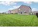 A spacious backyard featuring lush green grass, black metal fencing, and an extension of the home's back at 9498 Tobin Cir, Avon, IN 46123