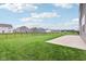 A spacious backyard featuring lush green grass, black metal fencing, and a concrete patio area at 9498 Tobin Cir, Avon, IN 46123