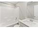This bathroom offers a shower-tub combo, sleek white fixtures and vanity with a quartz countertop at 9498 Tobin Cir, Avon, IN 46123
