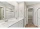Bathroom with double sinks, quartz countertop, and a doorway leading to a walk-in closet at 9498 Tobin Cir, Avon, IN 46123