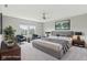 Bedroom staged with contemporary gray furniture, neutral walls, and a ceiling fan at 9498 Tobin Cir, Avon, IN 46123