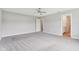 A large bedroom with neutral walls, carpet, a ceiling fan, and doorways to other rooms at 9498 Tobin Cir, Avon, IN 46123