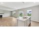 The home's open living area with fireplace and the white kitchen island with stainless dishwasher at 9498 Tobin Cir, Avon, IN 46123