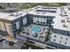 Aerial view of modern apartment building with a rooftop pool, lounge areas, and parking garage at 9728 Junction, Fishers, IN 46037