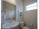 Half bathroom featuring modern fixtures, including a white sink, toilet, and window at 9728 Junction, Fishers, IN 46037