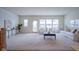 Bright, open living room featuring neutral tones, large windows and a decorative plant at 9728 Junction, Fishers, IN 46037