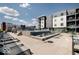 Upscale community pool with lounge chairs and tables with gray siding apartments in background at 9728 Junction, Fishers, IN 46037