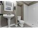 Neutral tone bathroom offering a pedestal sink and step-in shower with white tile at 9985 Ford Valley Ln, Zionsville, IN 46077