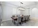 Well-lit dining room with long wood table, gray upholstered chairs, and contemporary chandelier at 9985 Ford Valley Ln, Zionsville, IN 46077