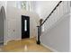 Bright foyer featuring high ceilings, hardwood floors, and a staircase with black and white railing at 9985 Ford Valley Ln, Zionsville, IN 46077