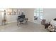 Bright home office with large window, gray desk, comfortable chair, and view into the living room at 9985 Ford Valley Ln, Zionsville, IN 46077