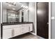 Modern bathroom boasts double vanity with black granite countertop and contemporary lighting fixtures at 1 Virginia Ave # 607, Indianapolis, IN 46204