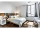 Bright bedroom with modern décor, wood floors, and a large window with city views at 1 Virginia Ave # 607, Indianapolis, IN 46204