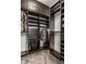 Custom walk-in closet with dark wood organizers, shelving, hanging rods, and storage for all at 1 Virginia Ave # 607, Indianapolis, IN 46204