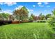 Large backyard featuring a well-maintained lawn, trees, and a wooden fence for privacy at 10758 Gettysburg Pl, Carmel, IN 46032