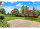 Brick patio overlooking a well-manicured lawn, mature trees, and flowerbeds in backyard at 10758 Gettysburg Pl, Carmel, IN 46032