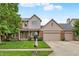 Charming home featuring a well-manicured lawn, brick facade, and a three-car garage with a basketball hoop at 10758 Gettysburg Pl, Carmel, IN 46032
