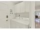 Bright laundry room with white washer and dryer, cabinets, and access to the main house at 10758 Gettysburg Pl, Carmel, IN 46032