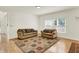 Bright living room with hardwood flooring, two couches and a patterned rug at 10758 Gettysburg Pl, Carmel, IN 46032