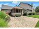 Rear exterior of home showcasing a screened-in porch and brick patio with lush landscaping at 10758 Gettysburg Pl, Carmel, IN 46032