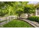 Beautifully landscaped front yard with stone walkway, lush greenery, and wrought-iron fence at 12505 Branford St, Carmel, IN 46032