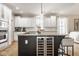 Well-lit kitchen featuring white cabinets, granite countertops, a kitchen island with a wine cooler, and stainless steel appliances at 12505 Branford St, Carmel, IN 46032
