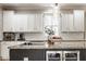Stylish kitchen featuring white cabinets, granite countertops, herringbone backsplash, and modern appliances for a premium cooking space at 12505 Branford St, Carmel, IN 46032