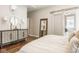 Stylish main bedroom showcasing hardwood floors, barn door, and elegant furniture at 12505 Branford St, Carmel, IN 46032