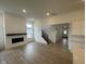Bright living room with modern fireplace, hardwood floors, and staircase at 13646 Grand Abbey Way, Fishers, IN 46037