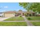 Charming brick ranch with attached garage, manicured lawn and inviting walkway to the front door at 1415 Section St, Plainfield, IN 46168