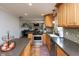 Well lit kitchen featuring wood cabinets, tile backsplash and stainless steel appliances overlooking the Gathering room at 1415 Section St, Plainfield, IN 46168