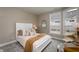 Bright bedroom with a large bed, decorative pillows, a wooden desk by a window, and neutral walls at 14892 Higgins Dr, Westfield, IN 46074