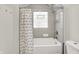 Neutral bathroom features a tub and shower combination with window and decorative curtain at 1531 English Ave, Indianapolis, IN 46201