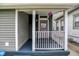 Charming covered front porch with railing and entryway featuring a painted purple door at 1531 English Ave, Indianapolis, IN 46201