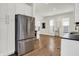 Open kitchen area leading to a bright living room with wood flooring and stainless steel appliances at 1531 English Ave, Indianapolis, IN 46201