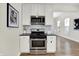 Kitchen featuring stainless steel appliances, white cabinets, and stylish backsplash at 1531 English Ave, Indianapolis, IN 46201