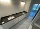 Modern bathroom with double vanity, dark countertop, white cabinets, and stylish tile flooring at 15352 Cardonia Rd, Fishers, IN 46037