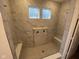 Luxurious walk-in shower featuring a tiled surround, a built-in seat, and sleek fixtures at 15352 Cardonia Rd, Fishers, IN 46037