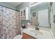 Well-lit bathroom featuring a vanity with a sink, a decorative mirror, and a shower with a floral curtain at 1896 Central Park W Blvd, Greenwood, IN 46143