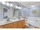 Bathroom features double sinks with a large mirror, a bathtub with tile surround, and modern fixtures at 1896 Central Park W Blvd, Greenwood, IN 46143
