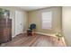 Cozy bedroom with wood-look flooring, a chair, and a window, creating a warm and inviting space at 1896 Central Park W Blvd, Greenwood, IN 46143