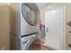 Laundry room features modern, stacked washer and dryer units with tile floors at 1896 Central Park W Blvd, Greenwood, IN 46143