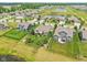An aerial view of a suburban neighborhood featuring beautifully landscaped yards and a community pond in the background at 19281 Scofield Ridge Blvd, Westfield, IN 46074