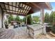 Covered patio features hot tub, fireplace, outdoor kitchen and ceiling fan overlooking grassy backyard at 19281 Scofield Ridge Blvd, Westfield, IN 46074