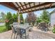 Outdoor kitchen and fireplace on patio of landscaped backyard with green grass and mature trees at 19281 Scofield Ridge Blvd, Westfield, IN 46074