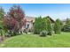 Landscaped backyard features a covered patio with outdoor seating and mature trees at 19281 Scofield Ridge Blvd, Westfield, IN 46074