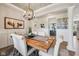 Charming dining room with a rustic wood table and view into the kitchen at 19281 Scofield Ridge Blvd, Westfield, IN 46074